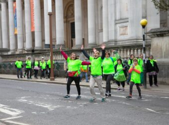 Males and females in green t-shirts outside Fitzwilliam