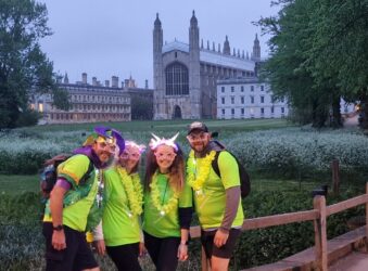 2 males and 2 females dressed in green in front of a large cathedral
