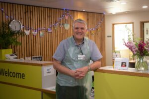 Male leaning on Reception smiling at the camera
