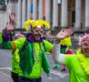 2 males and 1 females dressed in green and fancy dress smiling at the camera in front of Fitzwilliam Museum
