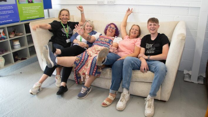 4 females and 1 male on a large white sofa