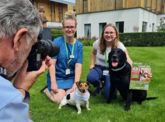 Male photographer taking photo of 2 females with 2 dogs