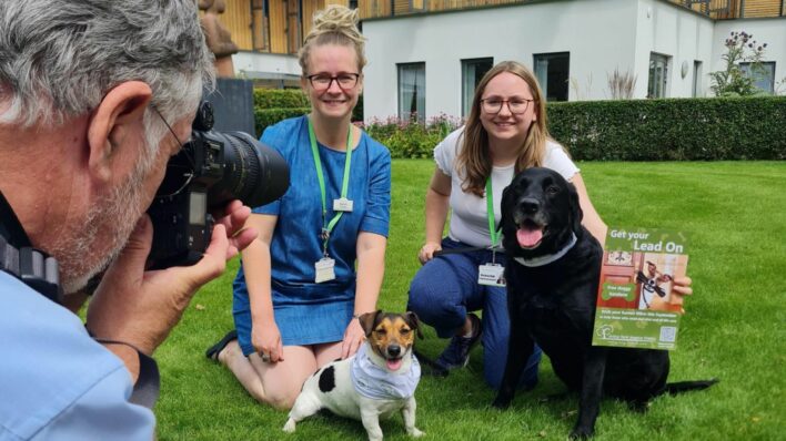Male photographer taking photo of 2 females with 2 dogs