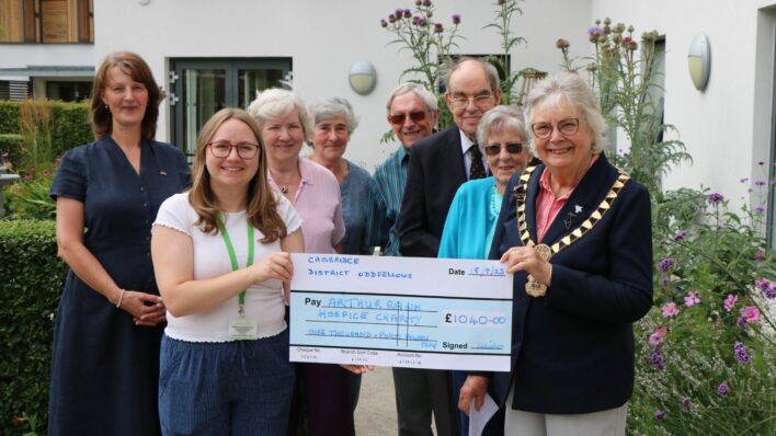 Image of Oddfellows presenting large cheque to community fundraiser in Hospice gardens