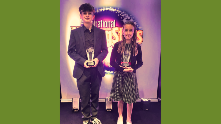 Young girl and boy holding awards