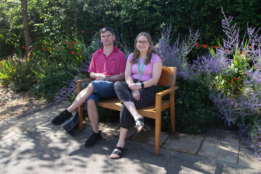Male and female sitting on a bench in the garden