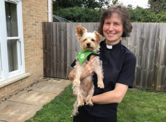 Female Vicar holding Yorkshire terrier