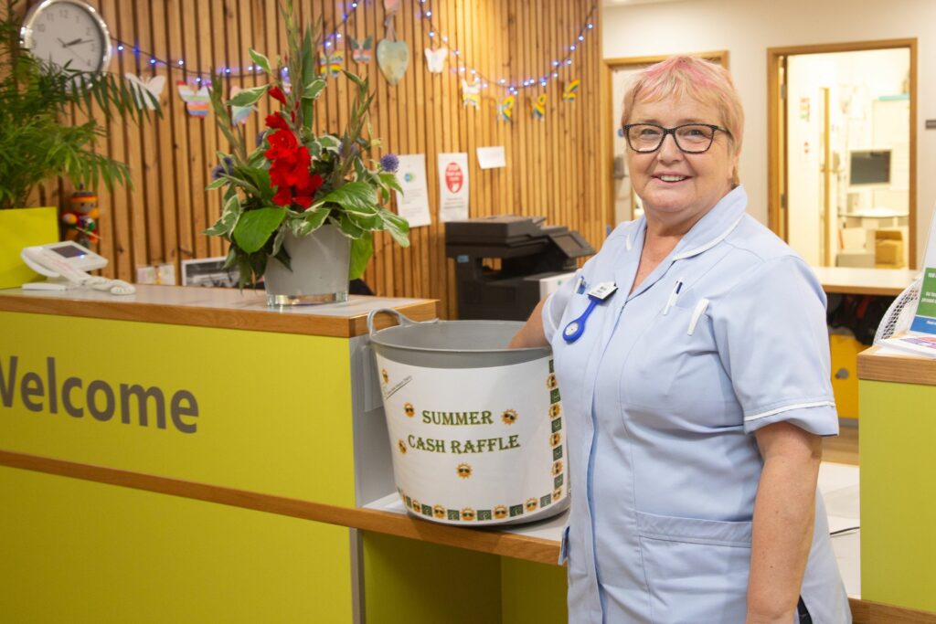 Female nurse taking a raffle ticket out of a big bucket