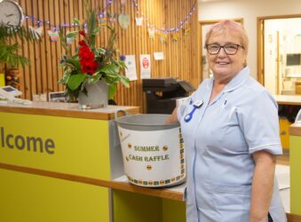 Female nurse taking a raffle ticket out of a big bucket