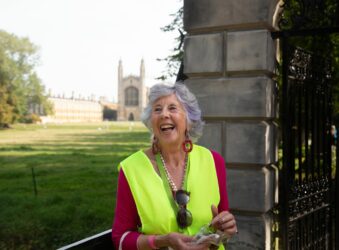 Female outside a gate with Kings College in the background