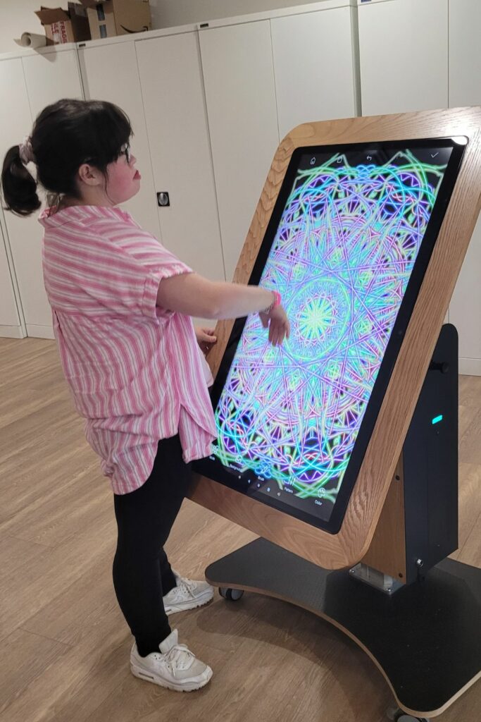 Young female standing next to a giant sized ipad