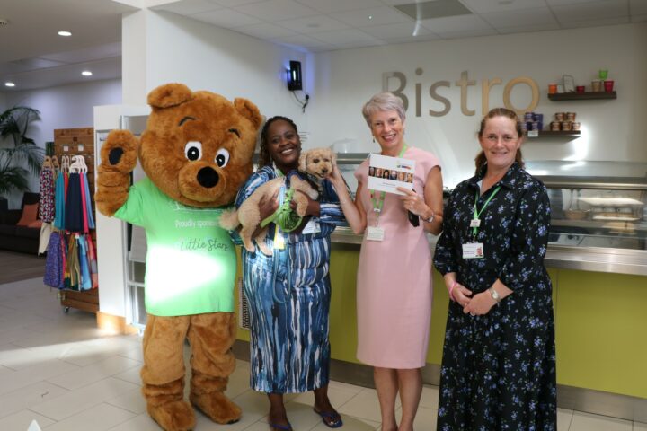 Life sized bear, and 3 females standing at a Bistro counter