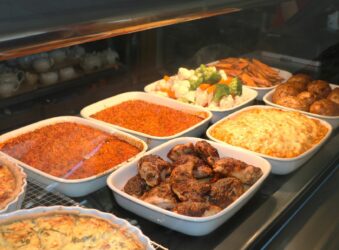 display of food. red spicy rice, jerk chicken, macaroni and cheese, steamed vegetables