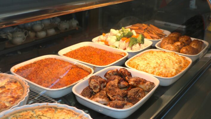 display of food. red spicy rice, jerk chicken, macaroni and cheese, steamed vegetables