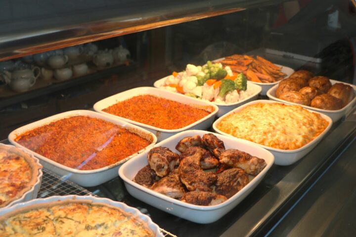 display of food. red spicy rice, jerk chicken, macaroni and cheese, steamed vegetables