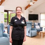 Female nurse standing near chairs in a lounge