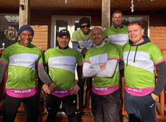 6 supporters in Team Arthurt-shirts outside cafe
