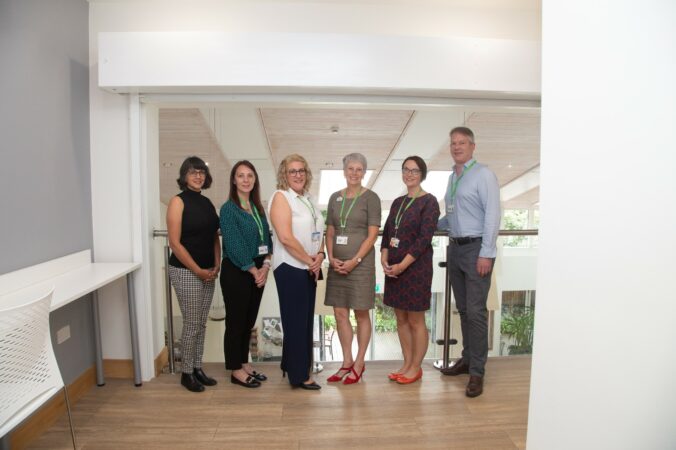 5 females and 1 male standing and looking at the camera
