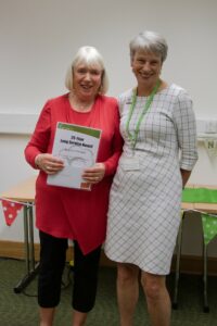 Two women standing next to each other and smiling at the camera