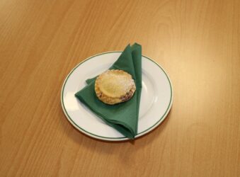 a single mince pie on a green napkin, on a white plate