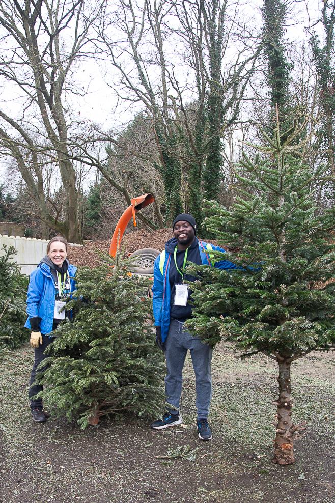 Female and a male standing outside with Christmas trees