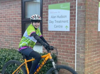Young boy on a bike with green branded top