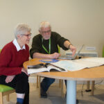 Female and male sitting at a table looking at map on the table