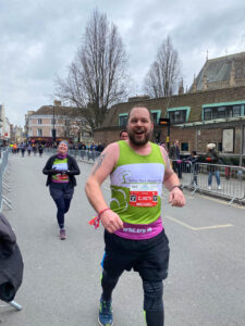 Male and female running in green vests