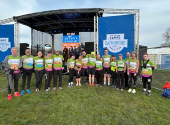 Group of males and females in a line, wearing green runner clothes