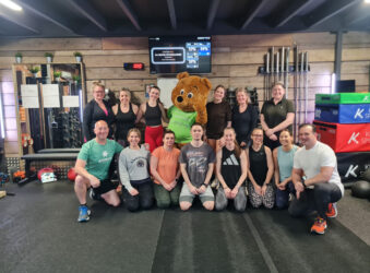 A group of male and females dressed for a workout in the gym