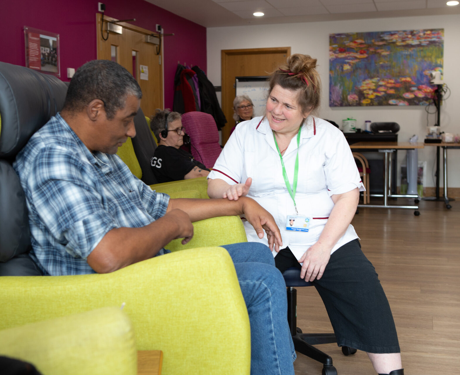Male sitting on a chair talking to a female nurse