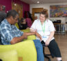 Male sitting on a chair talking to a female nurse