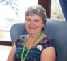 Female sitting on an arm chair, smiling at the camera