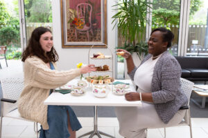 2 females sitting at a table with afternoon tea