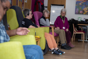 Male and females sitting in a chair