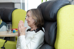 Female sitting in a chair with her hands together 