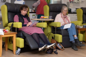Females sitting in a chair writing 