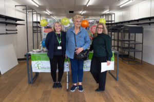 3 females standing in front of a table in an empty shop