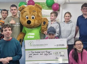 Arthur Bear, with teenagers and a teacher with a giant cheque from Granta School