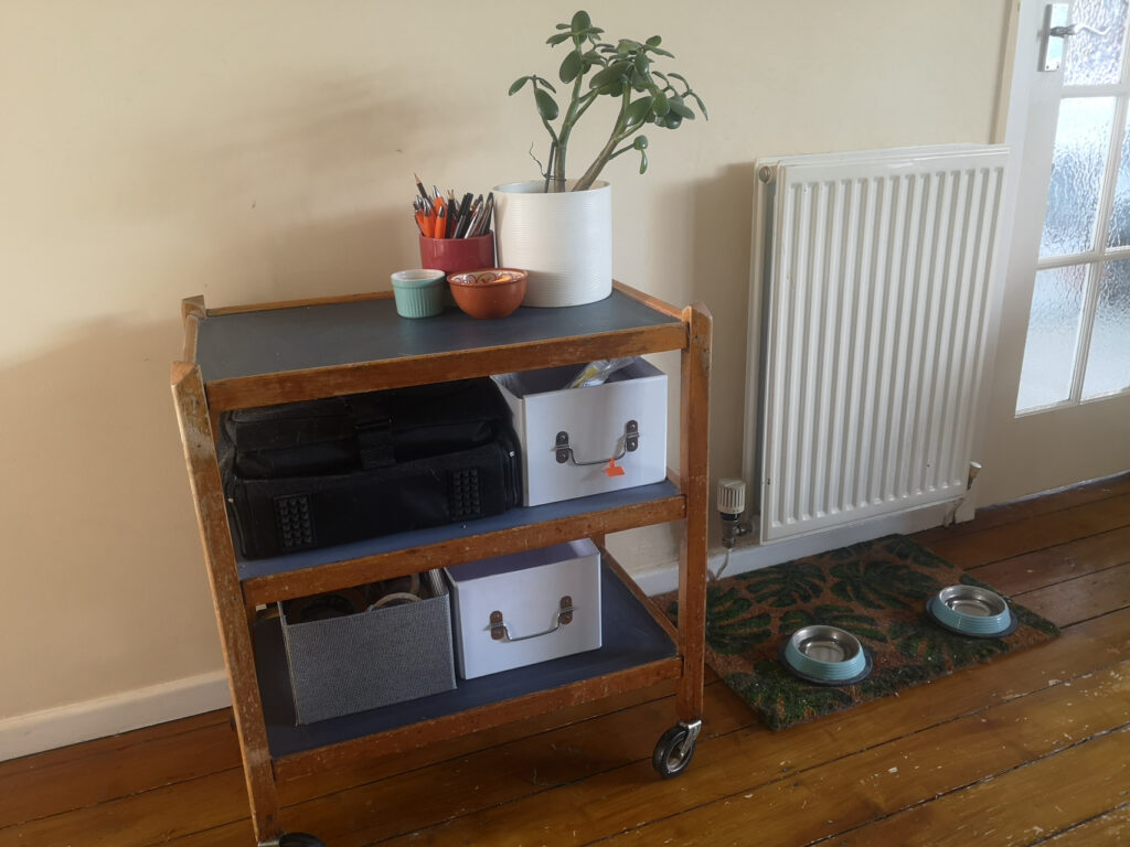 Blue and wooden trolley next to a radiator 