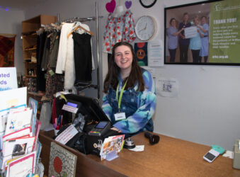 Female smiling, standing behind a desk