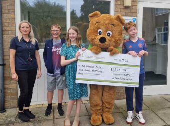 3 teenagers with giant cheque female teacher and lived sized bear