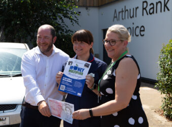Male and 2 females holding large £50 note