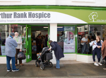 People standing outside a green and white shop