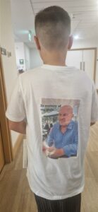 Back of boy in Tshirt with photo of middle age man in blue shirt