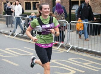 Female in green running gear, running in the street