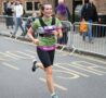 Female in green running gear, running in the street