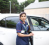 Nurse standing in front of a car