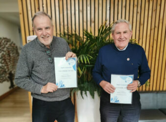 2 males holding certificates