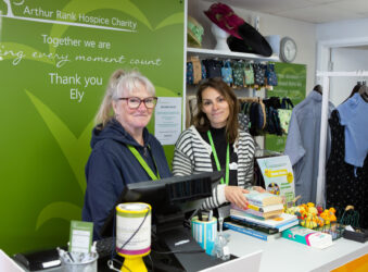 2 females standing behind a counter